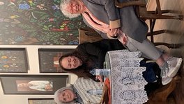 Three women sit at a table smiling