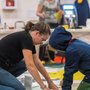 A photo of an artist and a kid working on an art piece together at a past Culture Days event.