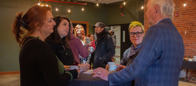 A photo of members of the cultural community talking at the BAE grant launch.