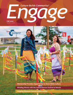 Cover of Engage Magazine Fall 2020 - Two people stand in a field beside colourful sticks and flags.