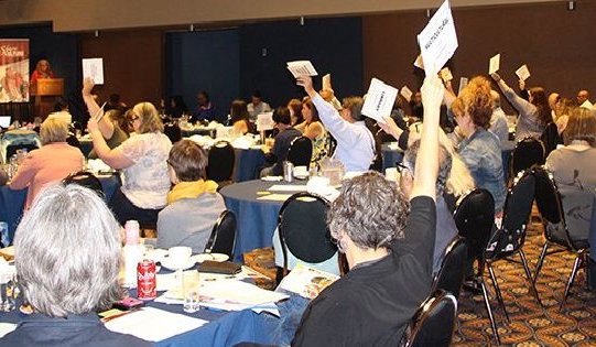 A photo of people voting at a past AGM.