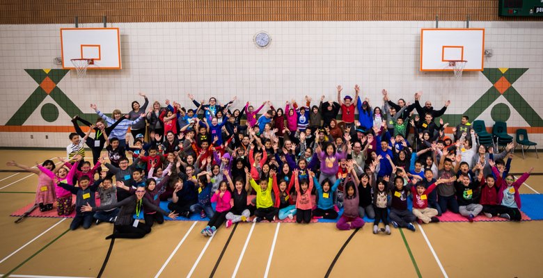 A big group photo of elementary school kids who participated in a ‘Circus and Magic Partnership’ event, smiling.