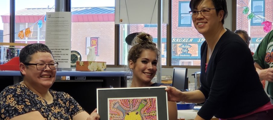 A photo of Harriet Roy (on the left), a long-time volunteer of SAS, presenting artwork.