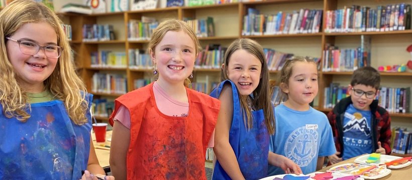 A photo of kids smiling and painting.