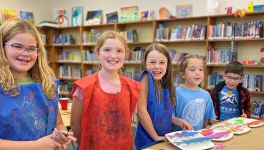 A photo of kids smiling and painting at an event funded by the NYCF.