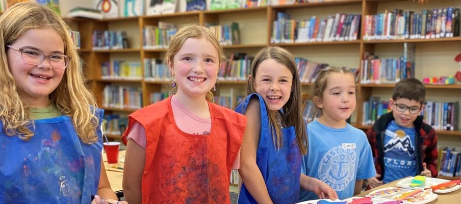 A photo of kids smiling and painting at an event funded by the NYCF.