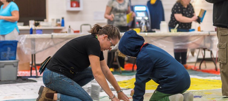 A photo of Monique Martin making an art installation with young kid at her 2023 Nuit Blanche Saskatoon installation.