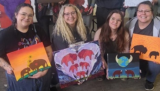 A group of people holding their buffalo paintings