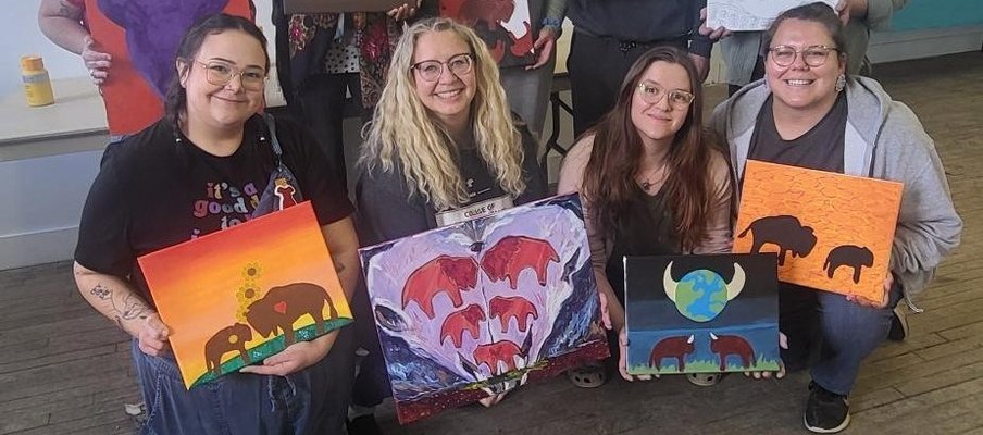 A group of people holding their buffalo paintings