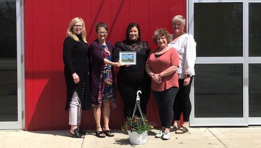 A photo of a volunteers receiving an award, posing with Rivers West District staff.