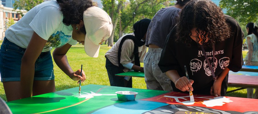 A photo of newcomer youth painting at an event by the Regina Open Door Society.