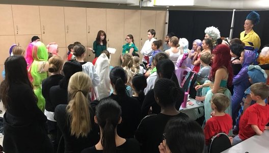 A photo of a group of theatre students in costuming, ready for a production.