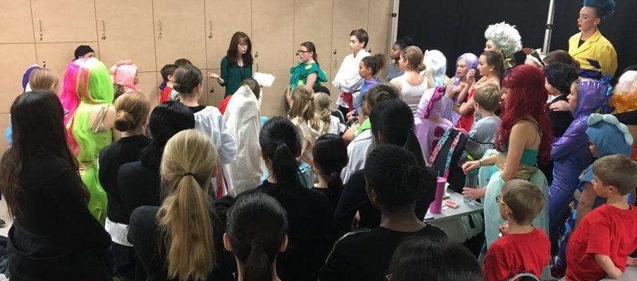 A photo of a group of theatre students in costuming, ready for a production.