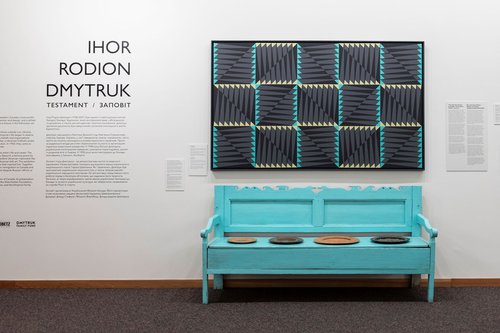 image of Ihor Rodion Dmytruk exhibition featuring a blue bench underneath a painting