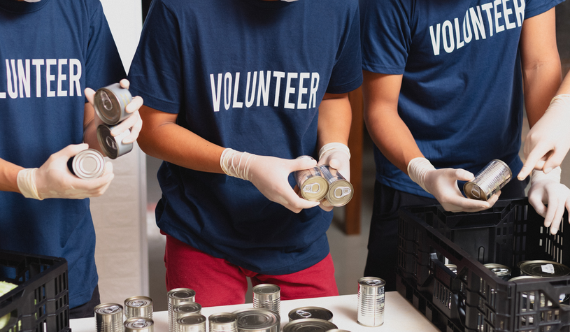 A photo of volunteers helping out in a food drive.