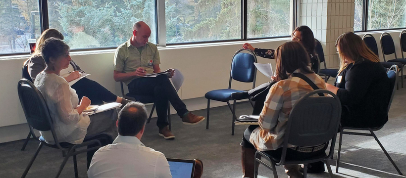 People engaging in a discussion while sitting in a circle at the 2022 ECO Gathering.