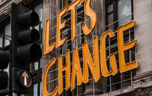 A large sign with orange text that reads "Let's Change"