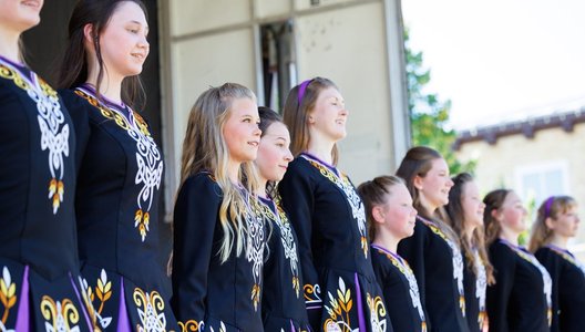 A photo of a line of young Prairie Gael School of Irish Dance dance students at a performance.