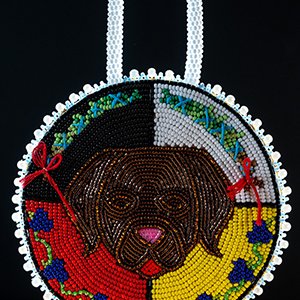 a colourful beaded medallion with a dogs face on it